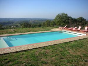 a swimming pool with chairs and a view at Casa Vacanze Podere Casacce in San Casciano in Val di Pesa