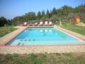 a large swimming pool with chairs at Casa Vacanze Podere Casacce in San Casciano in Val di Pesa