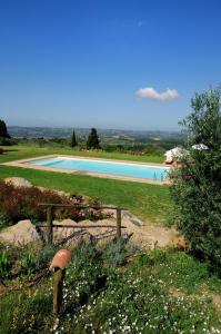 a swimming pool in a field with people in the background at Casa Vacanze Podere Casacce in San Casciano in Val di Pesa