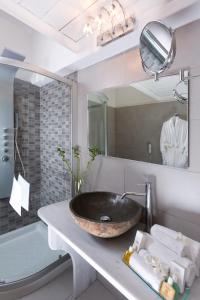 a bathroom with a sink and a large mirror at Tharroe of Mykonos Boutique Hotel in Mikonos