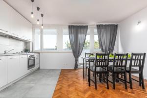 Apartaments Solec 79 by Renters في وارسو: مطبخ وغرفة طعام مع طاولة وكراسي