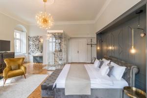 a bedroom with a large bed and a chair at Mid City Apartments in Cluj-Napoca