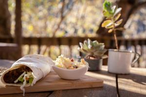 a burrito and a bowl of potato salad on a table at Treur River Lodge in Moremela