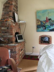 a room with a brick fireplace with a laptop on it at The old forge bed and breakfast in Dorchester