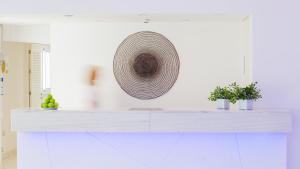 a kitchen with a white counter with a basket on the wall at Nissi Park Hotel in Ayia Napa
