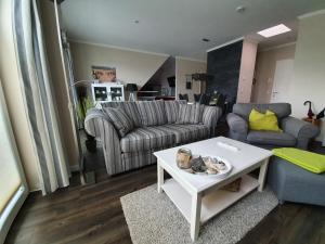 ein Wohnzimmer mit einem Sofa und einem Tisch in der Unterkunft Fewo Baltic Dreams in Börgerende-Rethwisch