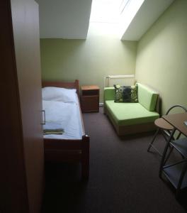 a bedroom with a bed and a green chair at Lucky apartmán in Svoboda nad Úpou
