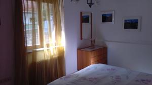 a bedroom with a bed and a window and a dresser at Chalet Migazzi in Cogolo