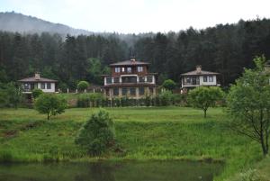 een groot huis in het midden van een veld bij Хотел Планински кът in Dorkovo