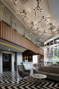 a lobby with a couch and a chair and a table at Verse Luxe Hotel Wahid Hasyim in Jakarta