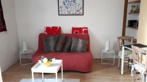 a living room with a red couch with pillows at Gîte L'Ermitage in Tours