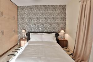 1 dormitorio con 1 cama grande y 2 lámparas en V Luxury Apartment 4 en Ioánina