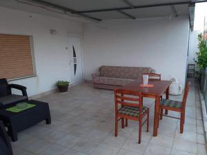 a living room with a table and chairs and a couch at Apartman Luce in Trogir