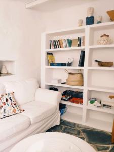 a living room with a white couch and bookshelves at Sifnos Twin Houses in Apollonia