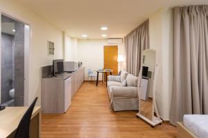 een woonkamer met een bank en een televisie in een kamer bij Athens Kyniska Studio in Athene