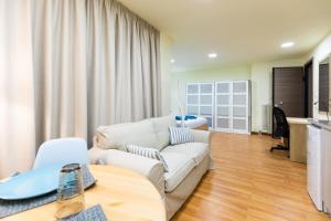 a living room with a white couch and a table at Athens Kyniska Studio in Athens