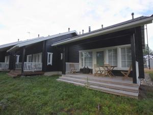 a black house with a deck and a table at Holiday Home Ylläskumpu 1 in Ylläsjärvi