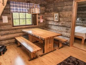 a dining room with a table and benches in a log cabin at Holiday Home Tortone by Interhome in Ruka