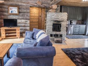 a living room with a blue couch and a stone fireplace at Holiday Home Tortone by Interhome in Ruka