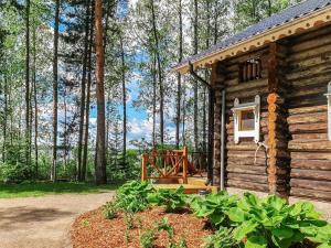 a log cabin in the woods with a porch at Holiday Home Matruusin majakka by Interhome in Onkamo