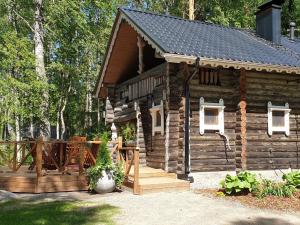 a log cabin with a porch and a deck at Holiday Home Matruusin majakka by Interhome in Onkamo