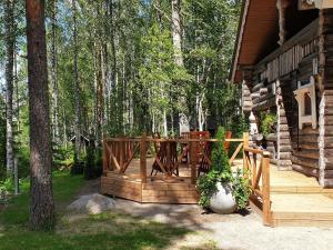 a porch of a log cabin with a vase of flowers at Holiday Home Matruusin majakka by Interhome in Onkamo