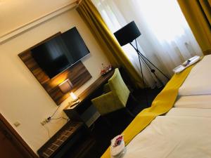 a hotel room with a bed and a flat screen tv at Hotel Milin in Reichenbach im Vogtland