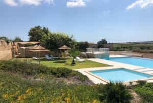 a villa with a swimming pool and a garden at Le Sorelle del Vino in Marzamemi