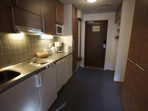 una pequeña cocina con armarios blancos y fregadero en Holiday Home Ylläs chalets 3207 by Interhome, en Ylläs