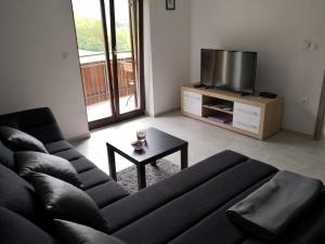a living room with a couch and a tv at Apartma Logar in Kobarid