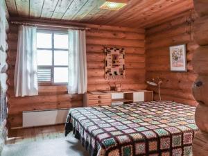 a bedroom with a bed in a log cabin at Holiday Home Revonkanta by Interhome in Kauhaniemi