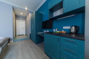 a blue kitchen with blue cabinets and a counter top at Partner Guest House Shota Rustaveli in Kyiv