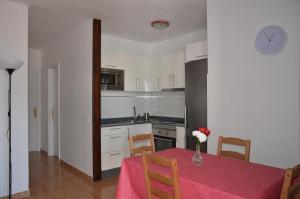 a kitchen with a table with a vase of flowers on it at Apartamento Manuela in Puerto del Carmen