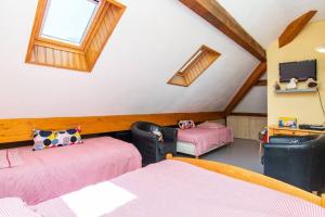 a attic room with two beds and a tv at Maison 8 personnes au coeur de la vallée du Louron in Loudenvielle