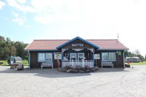 un piccolo edificio con due panchine di fronte di Skotteksgården Cottages a Ulricehamn