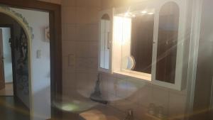 ein Badezimmer mit einem Spiegel und einem Waschbecken in der Unterkunft Ferienwohnung Winklhofer in Mondsee