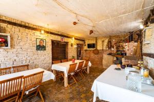 a restaurant with tables and chairs and a brick wall at Apartmani Lovre Posedarje in Posedarje