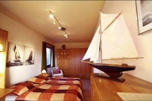ein Schlafzimmer mit einem hölzernen Segelboot auf einem Tisch in der Unterkunft Stadtapartment in Lübeck