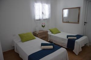 a room with two beds and a mirror at Apartamento Manuela in Puerto del Carmen