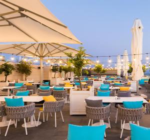 a restaurant with tables and chairs and umbrellas at Lancaster Eden Bay in Beirut