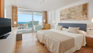 a bedroom with a bed and a television and a balcony at Hipotels Playa de Palma Palace&Spa in Playa de Palma