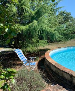 une chaise bleue assise à côté de la piscine dans l'établissement La Meyssonnié, à Damiatte