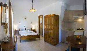 a bedroom with a bed and a kitchen with a table at Tanias House in Platanias