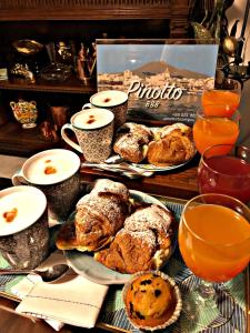 a table with plates of pastries and cups of orange juice at PINOTTO BNB in Torre Annunziata