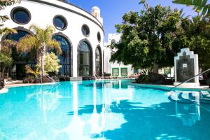 a swimming pool with blue water in front of a building at Hotel LIVVO Volcán Lanzarote in Playa Blanca
