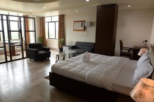 1 dormitorio con 1 cama grande y sala de estar en Hotel Lake Shilloi, en Dimāpur