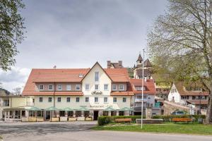 ein großes weißes Gebäude mit rotem Dach in der Unterkunft Hotel Rössle Berneck in Altensteig