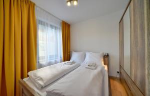 1 dormitorio con cama blanca y ventana en Apartamenty Sun Seasons 24 - Triventi, en Karpacz