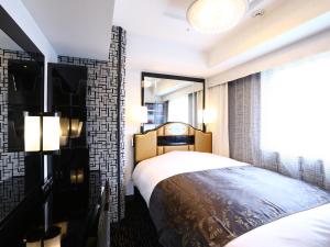 a bedroom with a bed and a large window at APA Hotel Ayase Ekimae in Tokyo