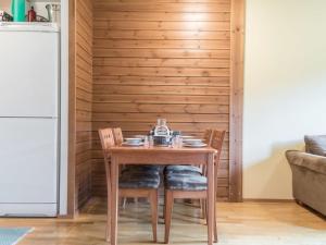 a wooden table and chairs in a kitchen with a refrigerator at Holiday Home Ylläs chalets a507 by Interhome in Ylläsjärvi